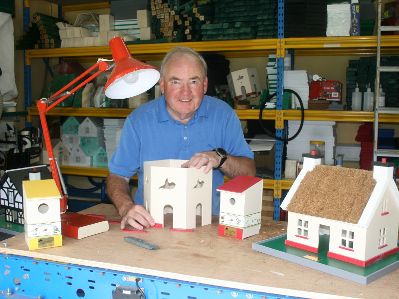 Man building birdhouses in his garage.