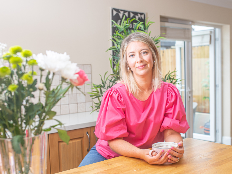 Blonde-haired woman in pink blouse.