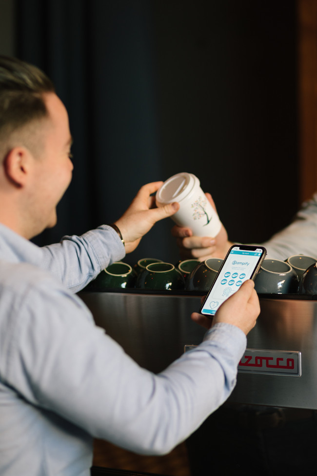 Person paying for coffee with their smartphone.