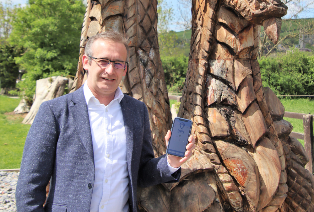 Man in blue jacket holding a mobile phone.