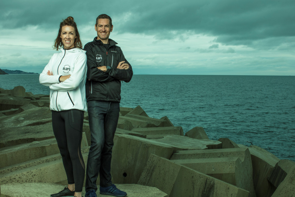 Man and woman standing beside the sea.