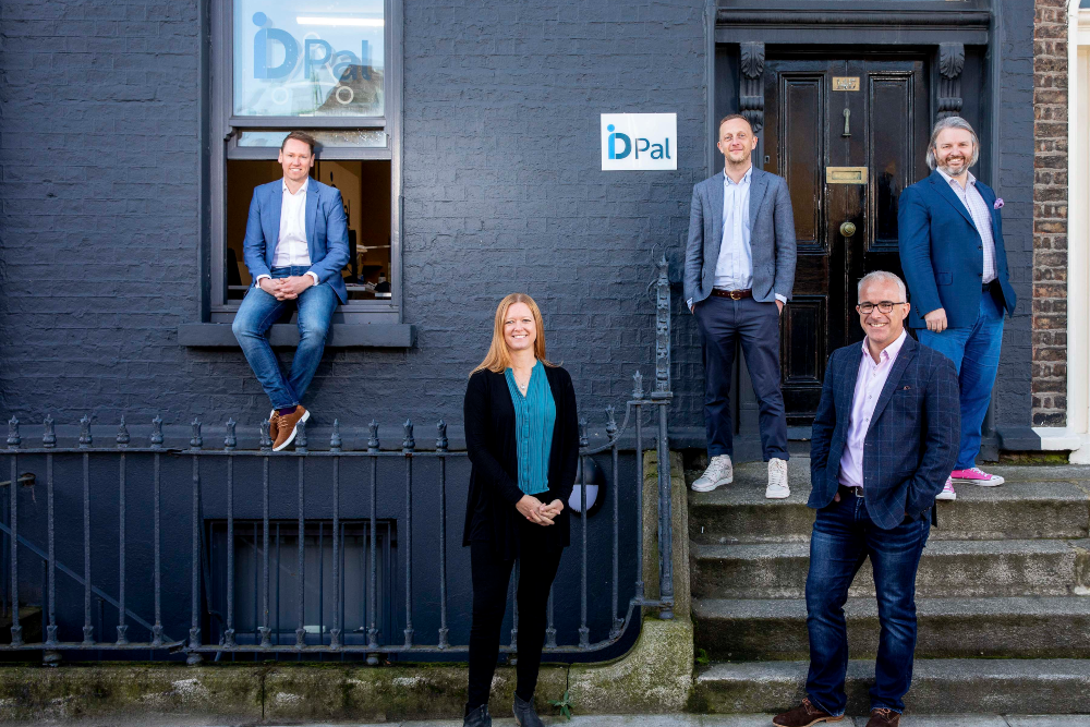 Four men and a woman outside a building.