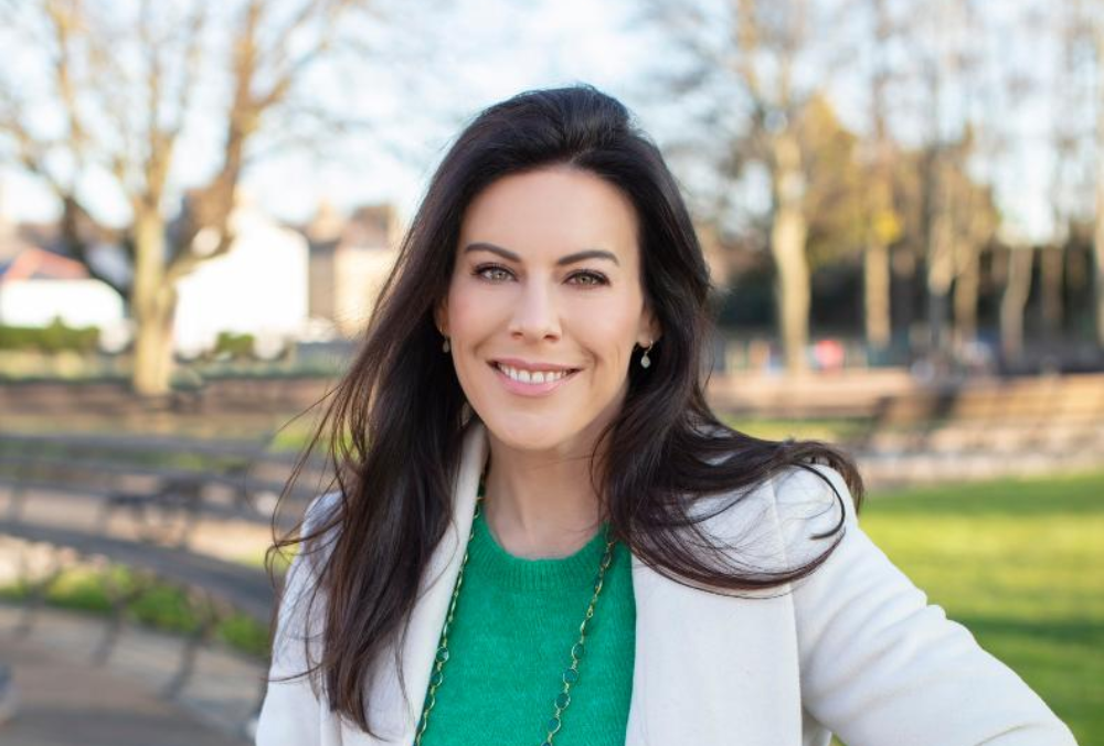 Dark-haired woman sitting in a park.