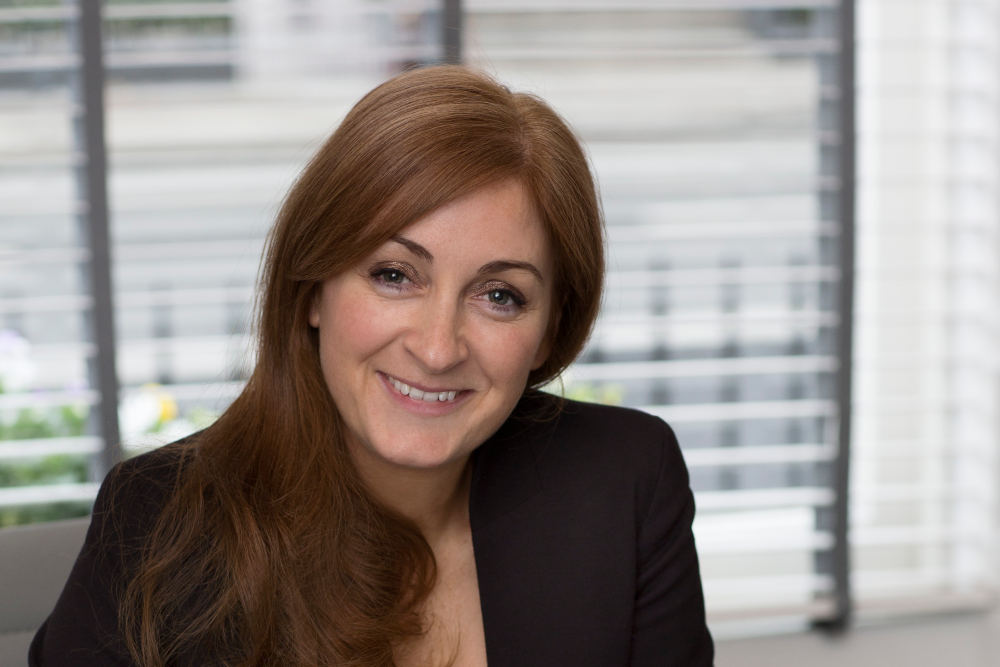 Auburn-haired woman wearing black jacket.