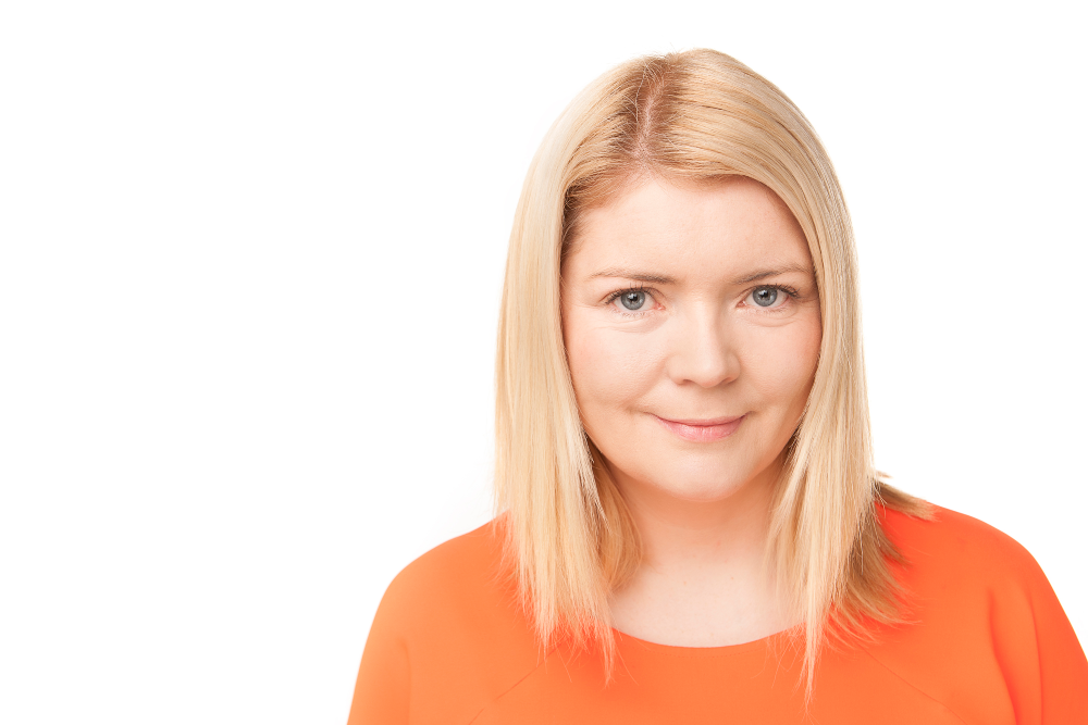 Blonde-haired woman wearing orange top.