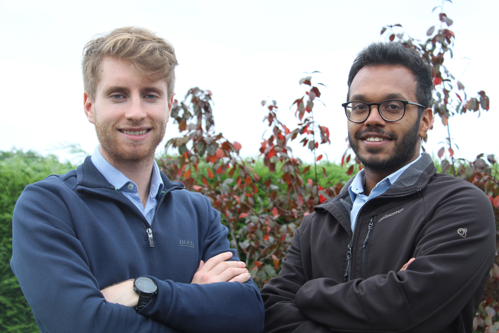 Two young men with arms folded.