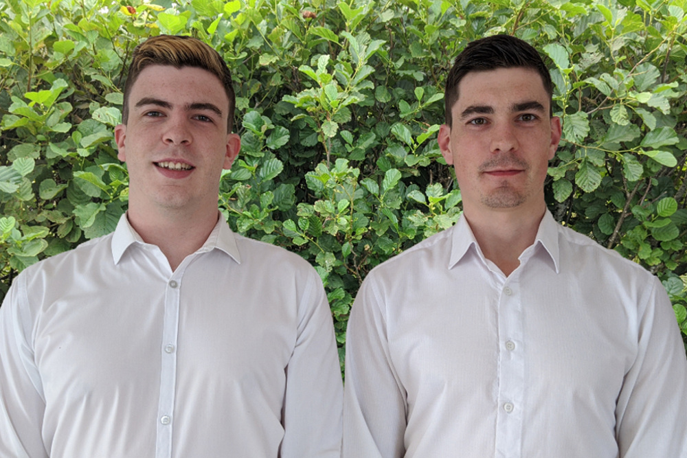 Two young men in white shirts.