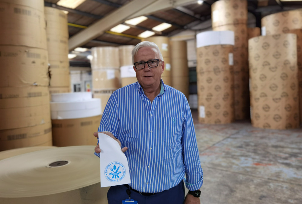 Man in blue shirt holding an envelope.