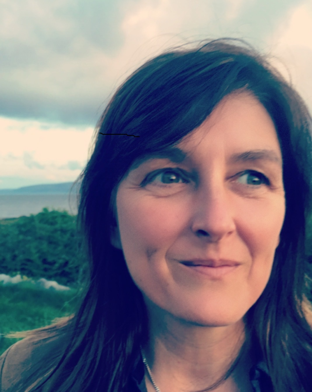 Dark-haired woman in countryside.