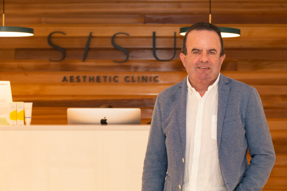 Man in blue jacket standing in a SISU clinic.