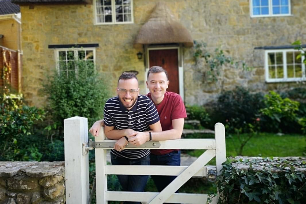 Two men standing in front of a house.