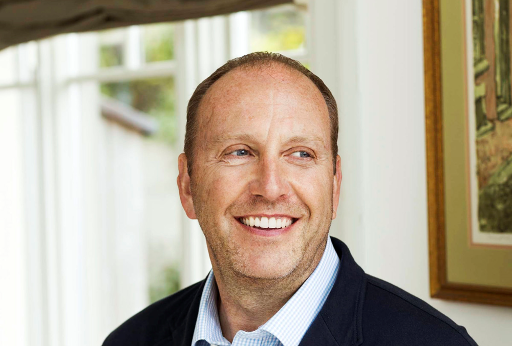 Smiling man in navy jacket.