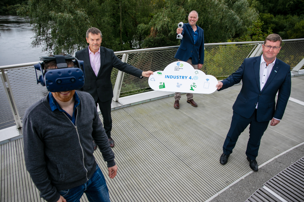 Four men standing on a bridge.