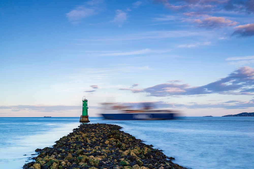 ship passing lighthouse in Dublin bay.