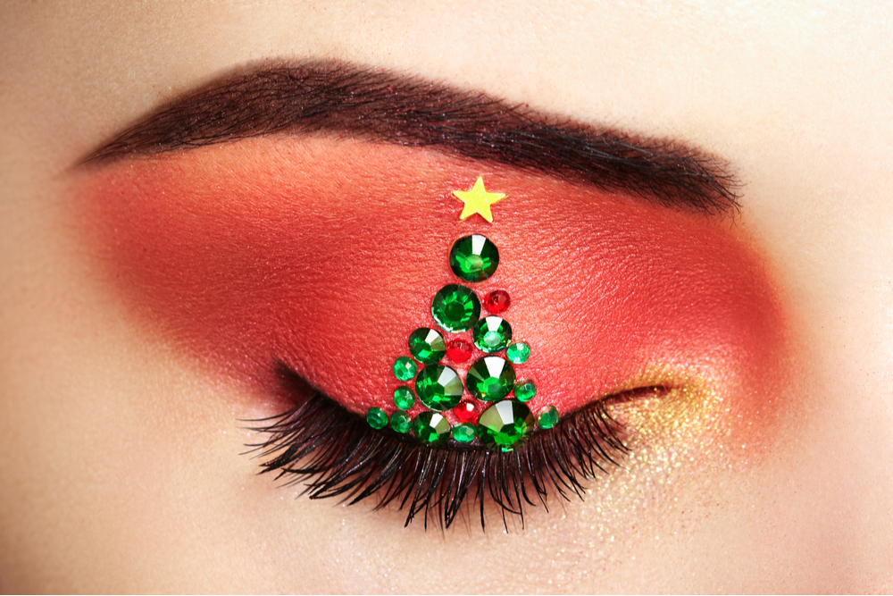 Woman in make-up with Christmas tree design.