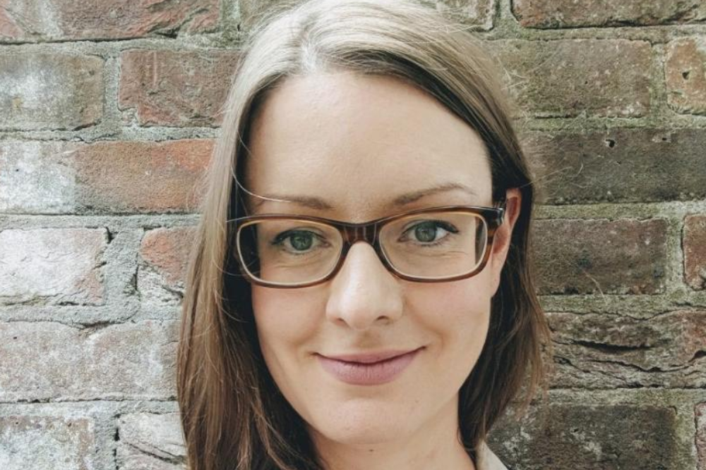 Brown-haired young woman in glasses.