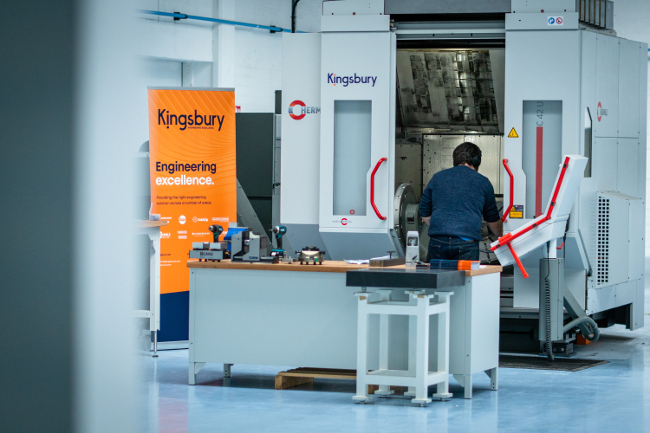 Man working with large 3D printing machine.