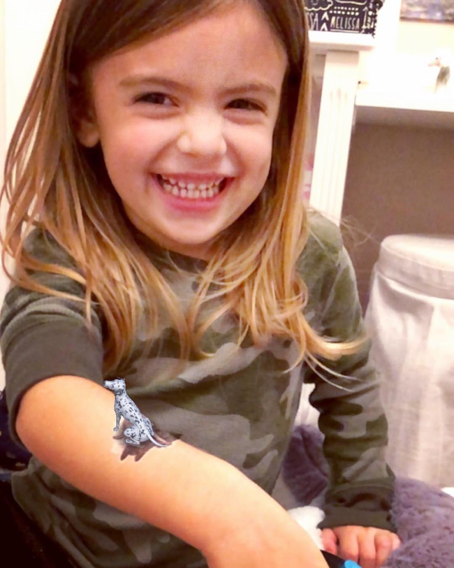 Young girl with an augmented reality tattoo on her arm.