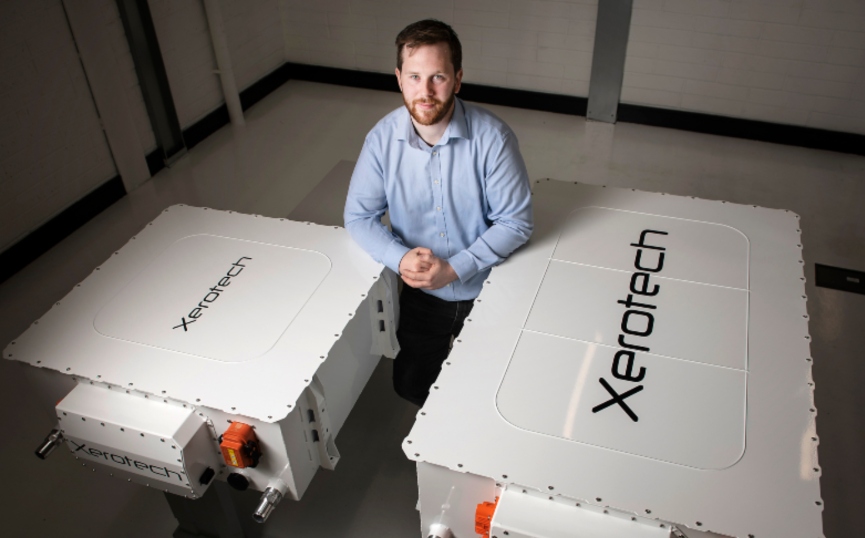 Man standing between two big batteries.