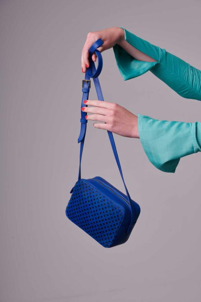 woman holding a blue handbag.