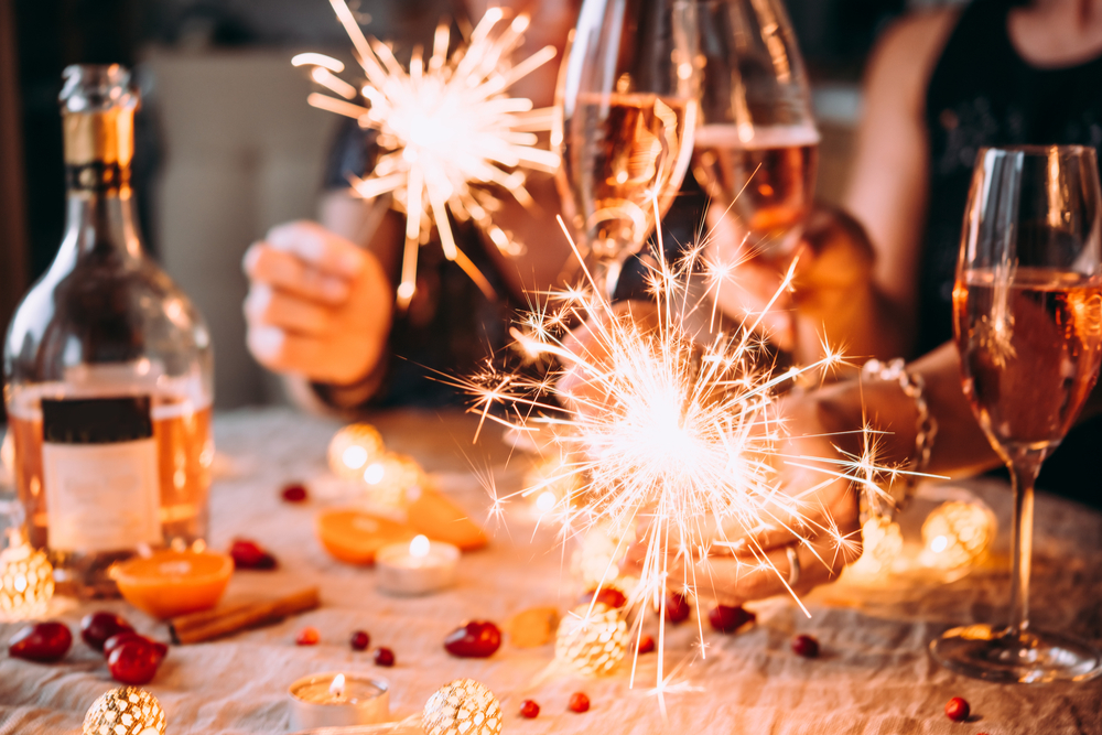 People enjoying Christmas drinks with sparklers.