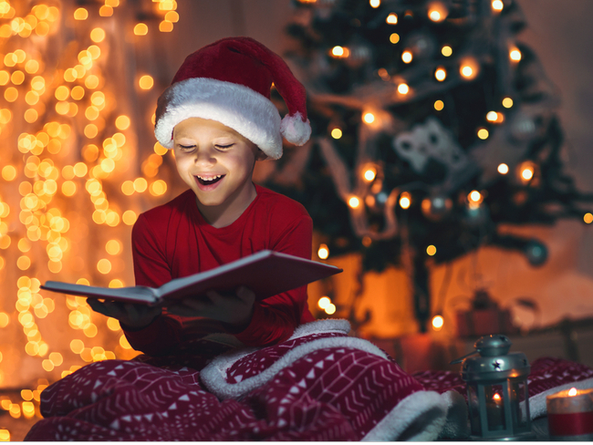 Kid reading a book at christmas.