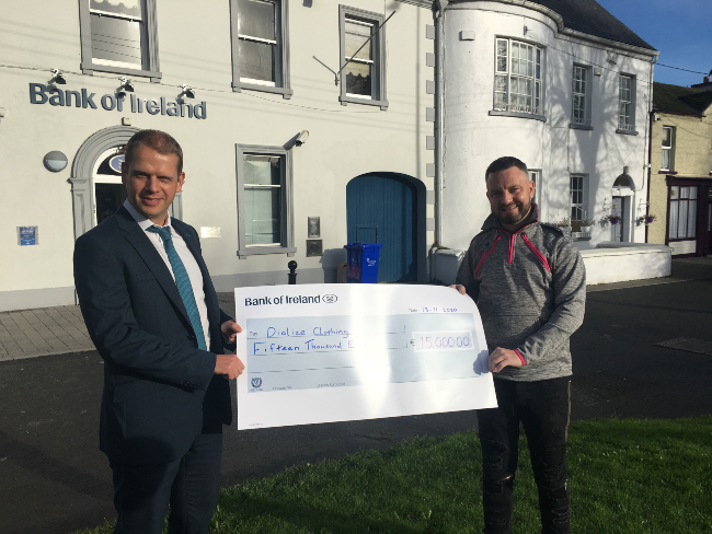 Two men holding a big cheque.