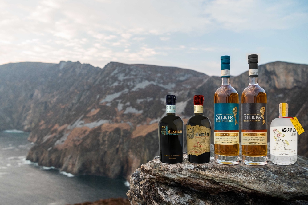 Bottles of whiskey in front of a sea cliff.