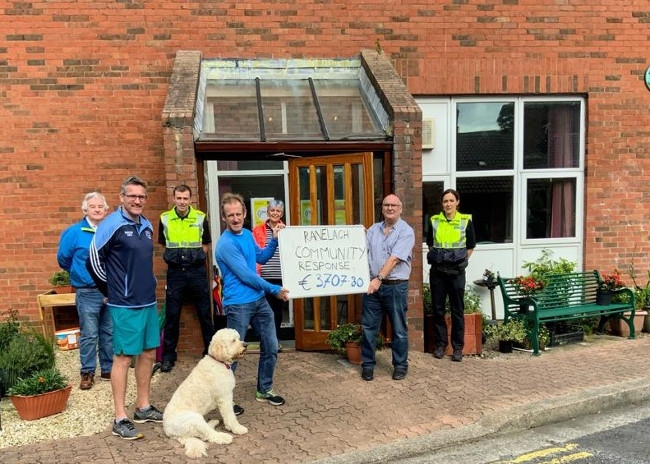 People outside a community centre holding a cheque.