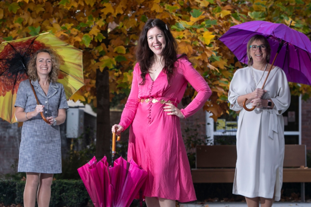 Three women holding umbrellas.