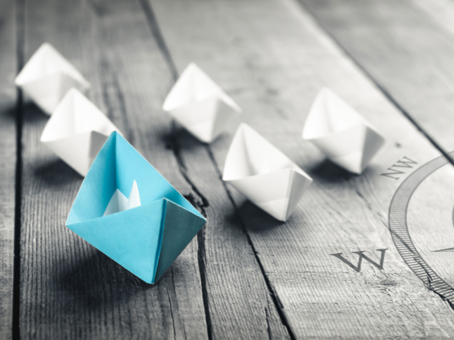 blue and white paper boats beside a compass.