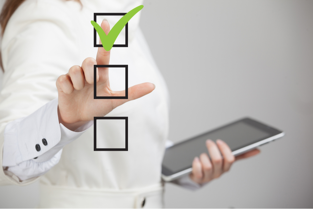 Woman checking a list off on a screen.