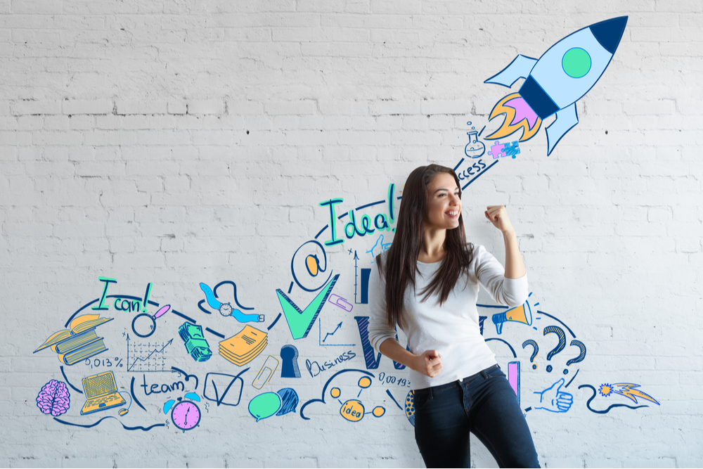 Woman entrepreneur standing before gravity of a rocket on a wall.