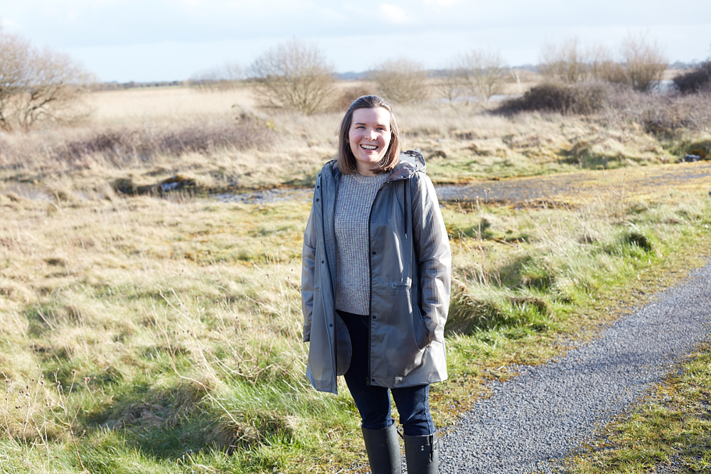 Young woman standing in countryside.