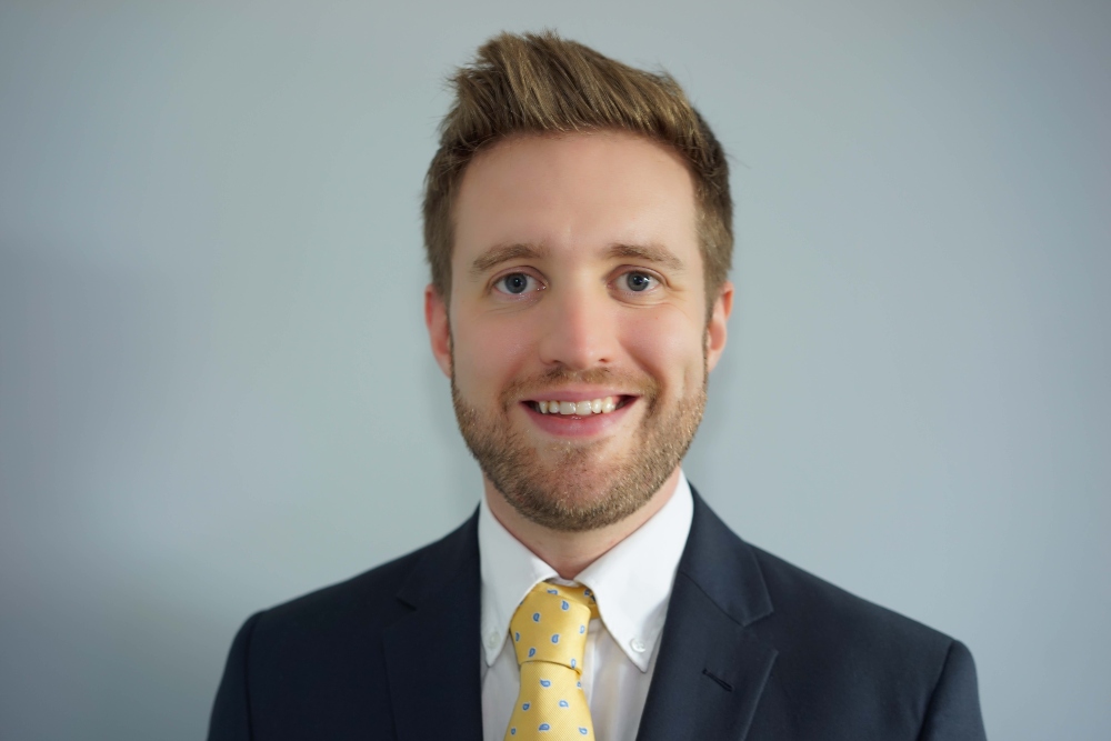 Young man in suit with yellow tie.