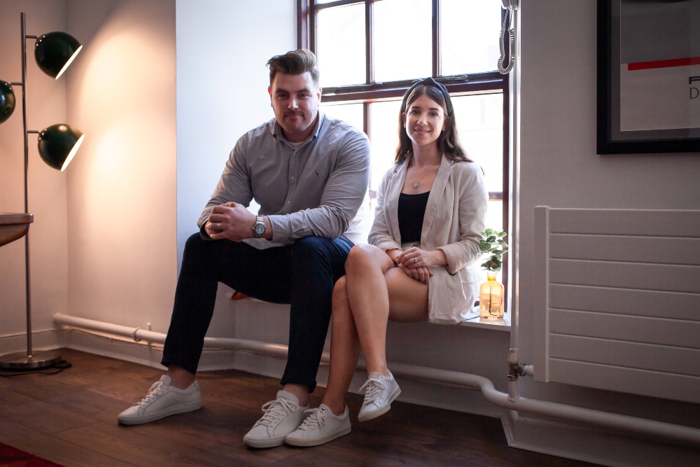 Young man and woman sitting on a window sill.