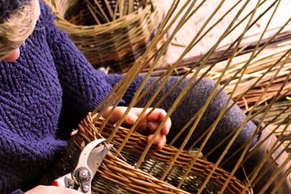Woman weaving a basket.