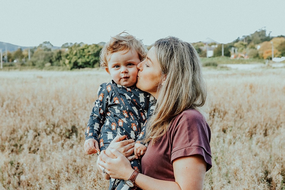 Mother and son standing in a field.