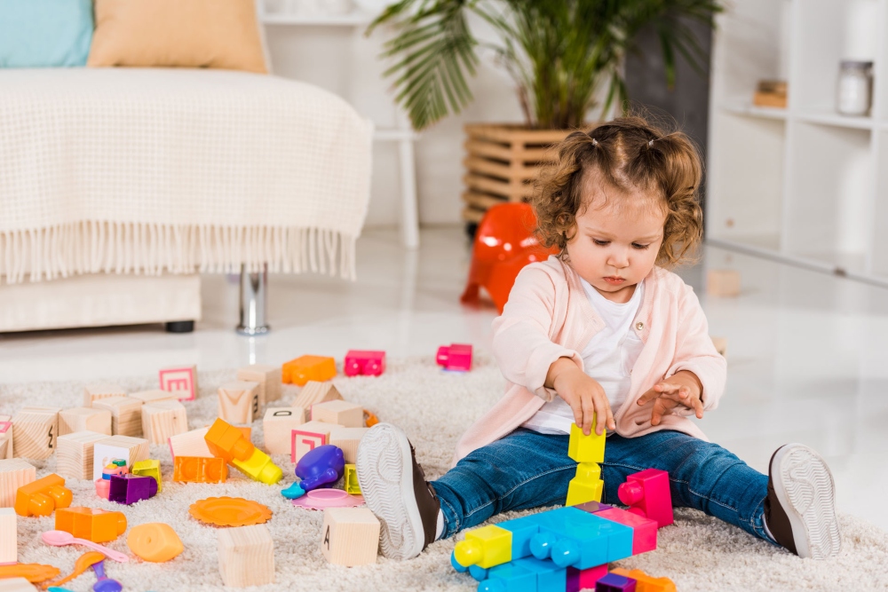 Adorable child playing with blocks.
