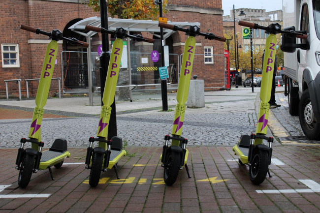 Zipp Mobility scooters parked on a street.