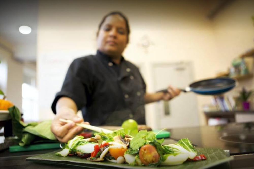 Woman chef cooking in kitchen.