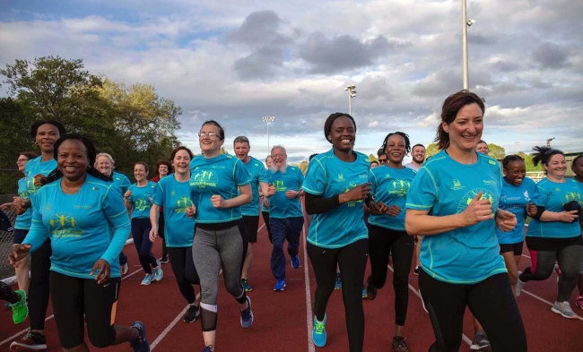 women in blue t-shirts at a running event.