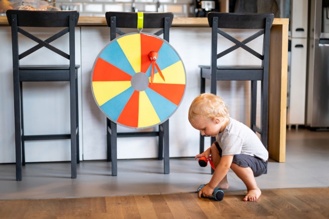 Little boy playing with dart board.