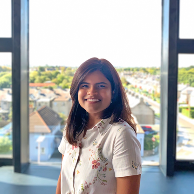 Young smiling woman in front of a window.