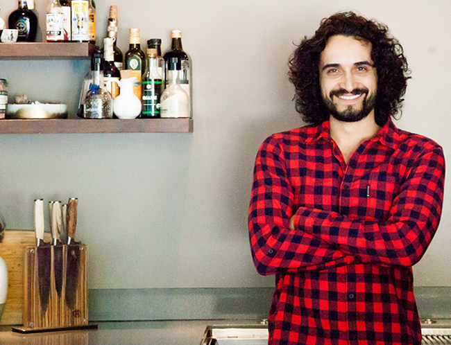 Man in checkered shirt in kitchen.