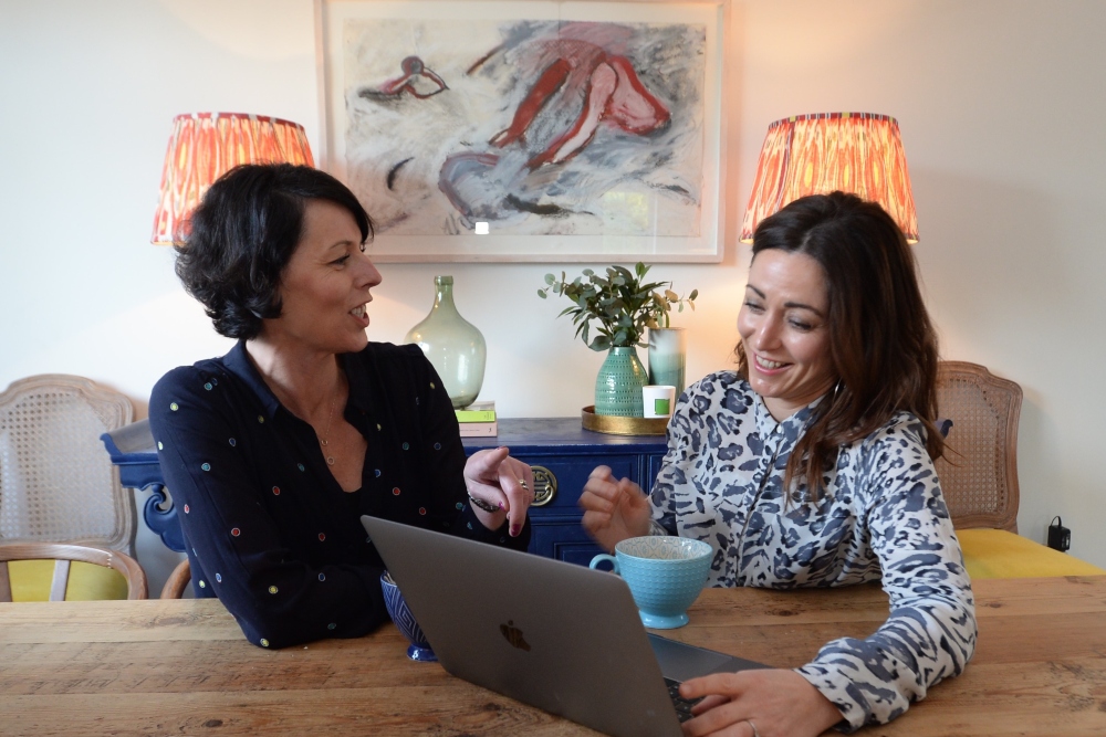 Two women collaborating with a notebook computer.