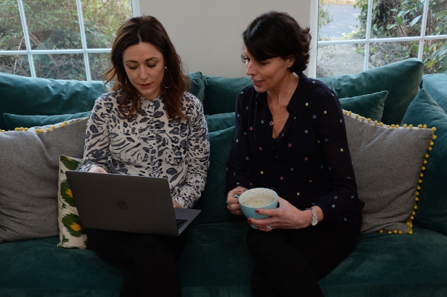 Two women looking at a laptop.