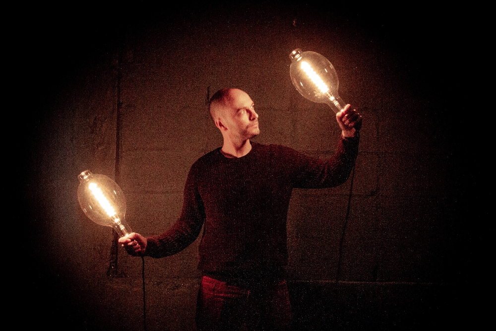 Man holding up light bulbs.