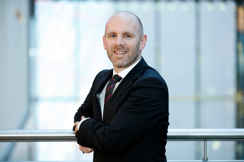 Man in suit standing in office building.