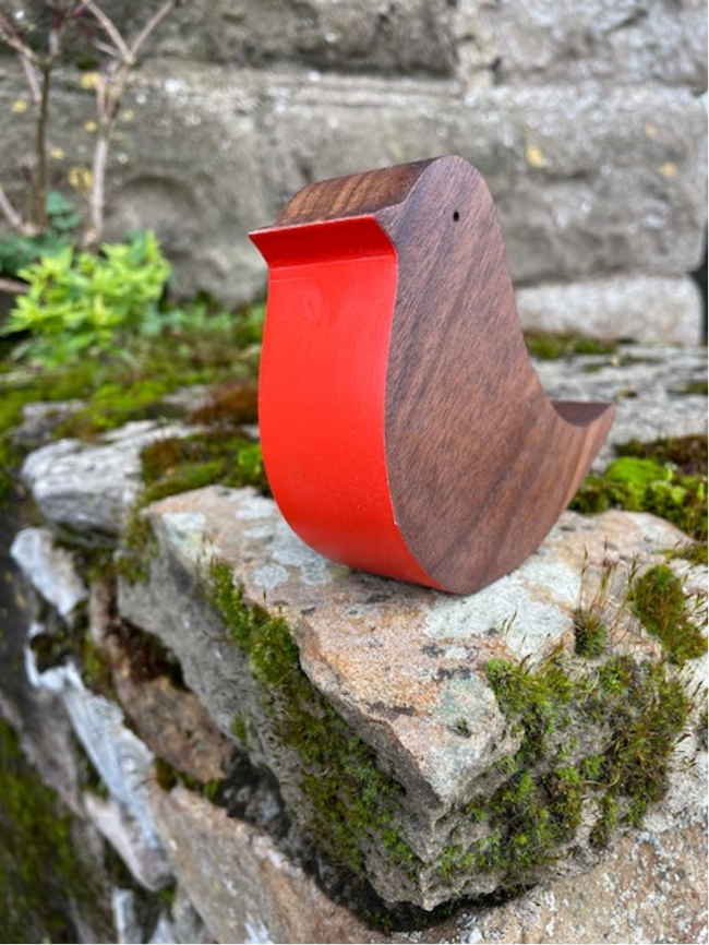 Wooden robin on a wall.